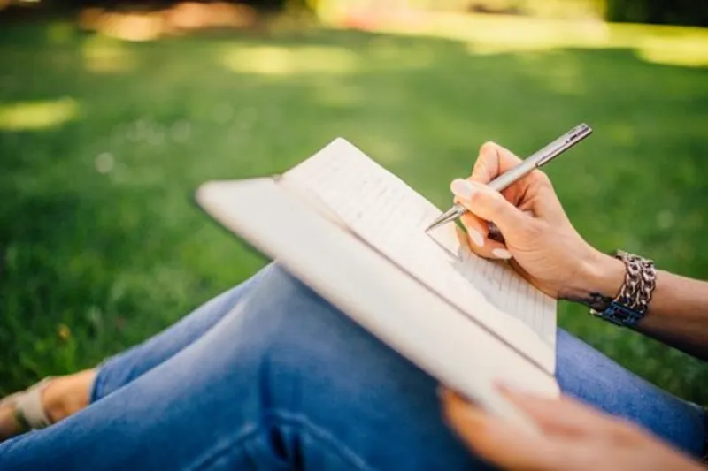 An open paper journal with a pen resting on it